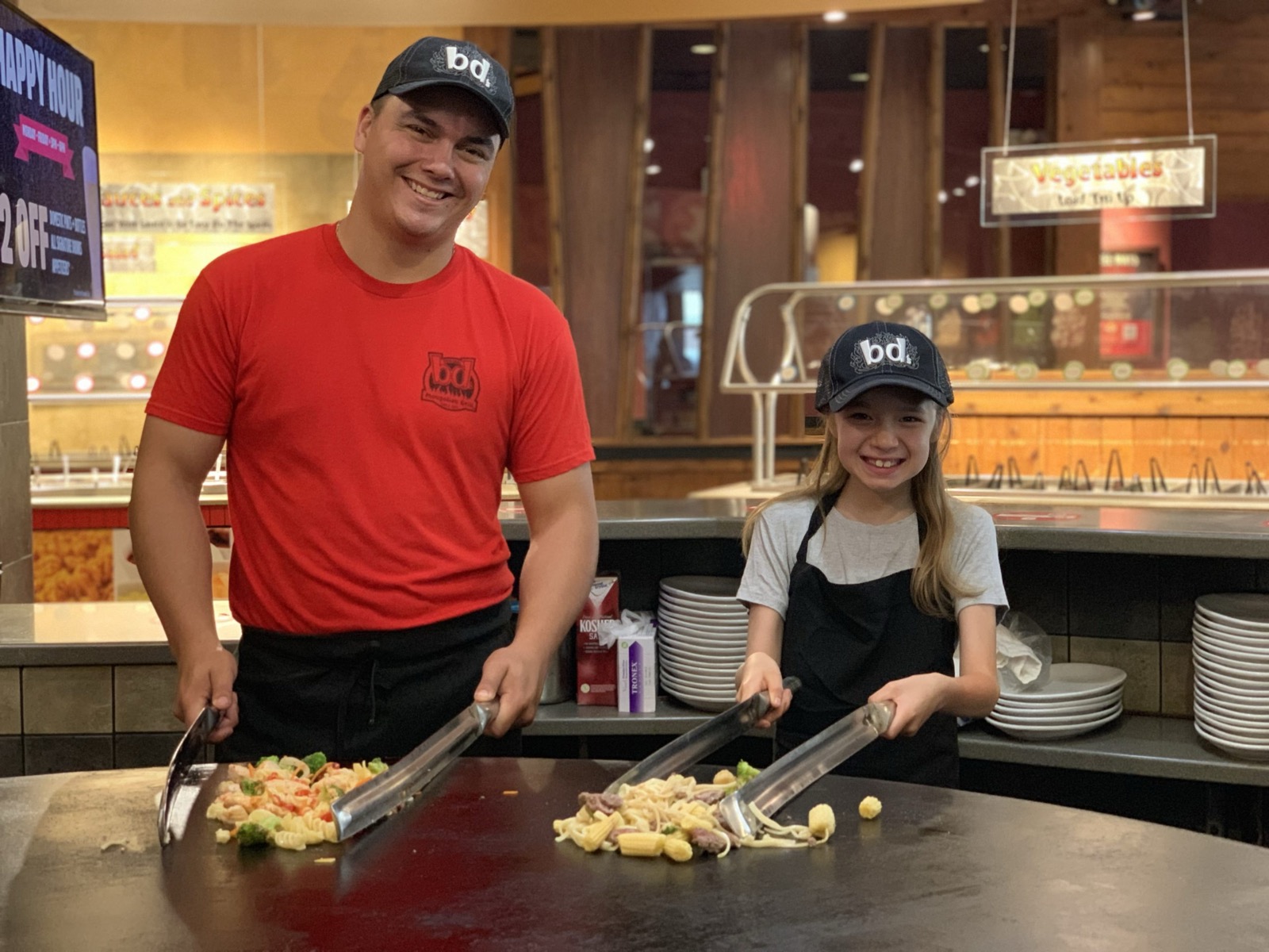 BD's grillers preparing made-to-order stir-fry bowls